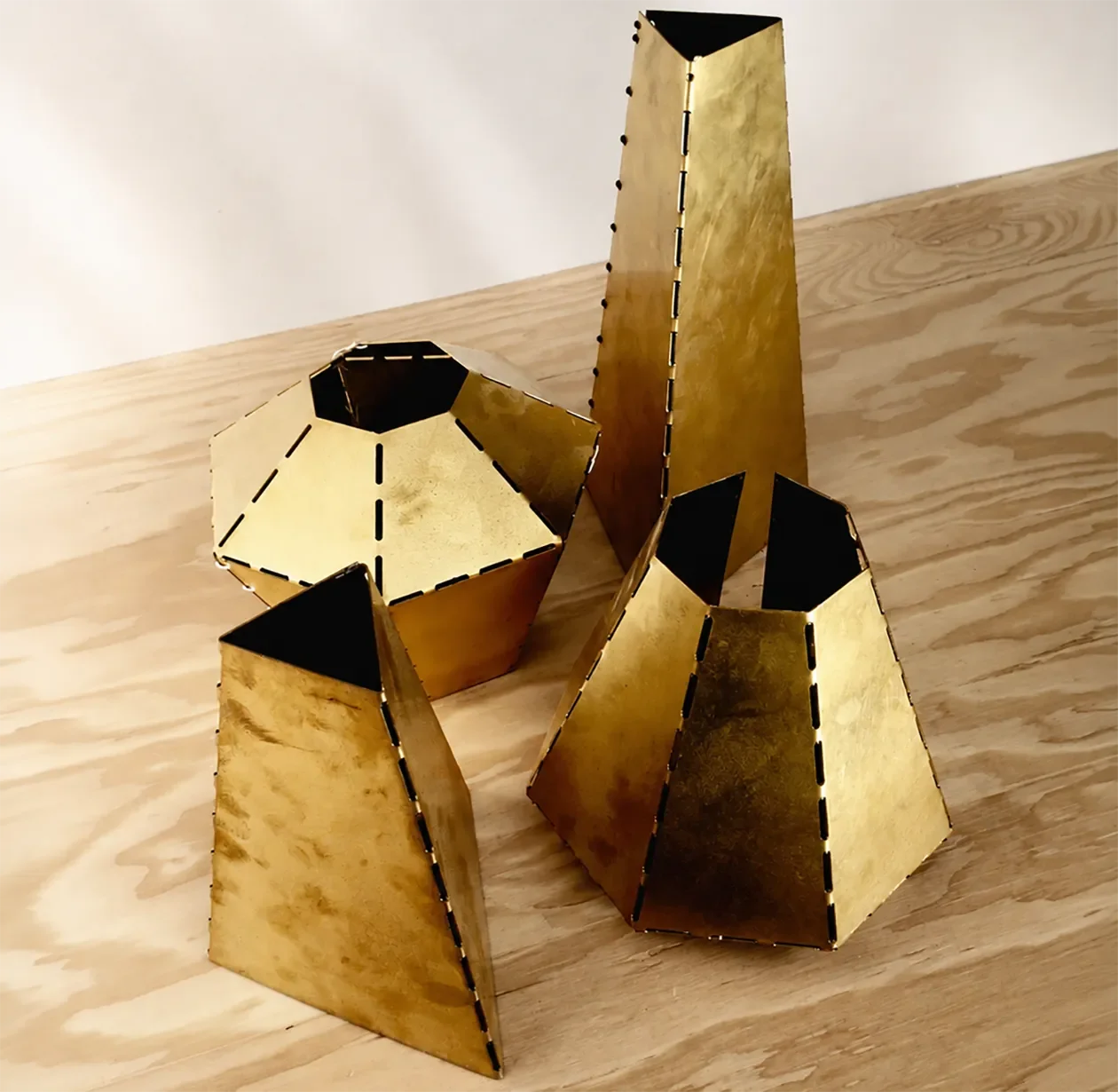 Metal prototype mockups of a faceted fixture on the bench at Tecture AF.