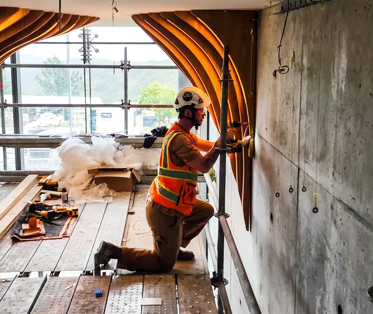 A Tecture AF Fabricator and Installer installing a curved wood ceiling feature on site in San Diego.