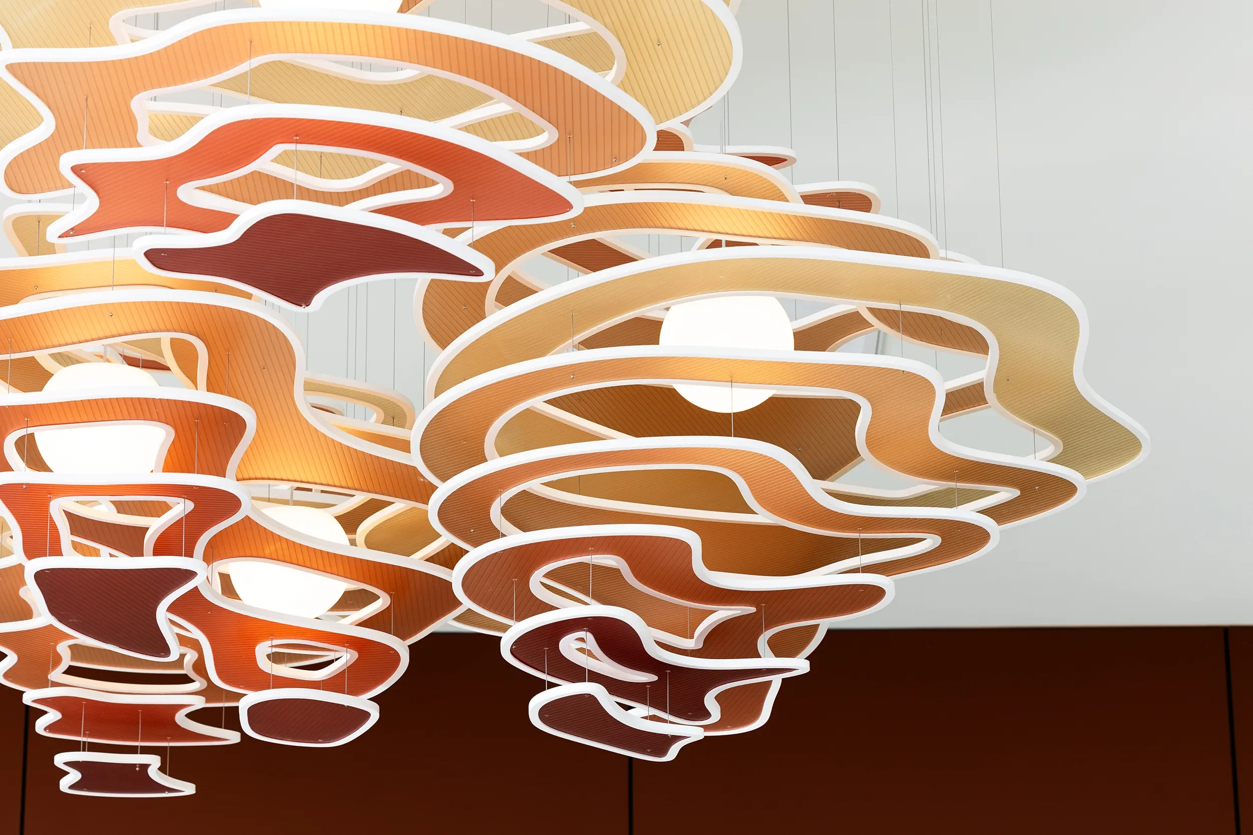 Layered sculptural pendant cluster in amber and rust tones, custom fabricated in San Diego