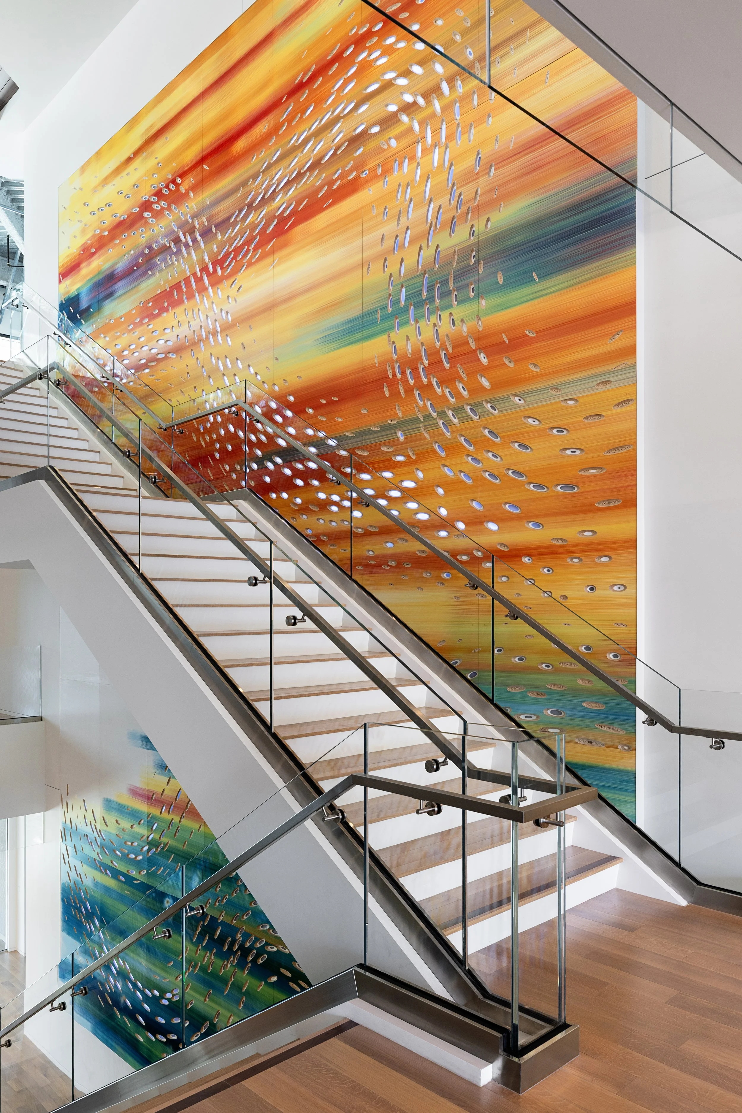 Convergence seen in full, a forty foot painted and illuminated wall sculpture running alongside an open stair