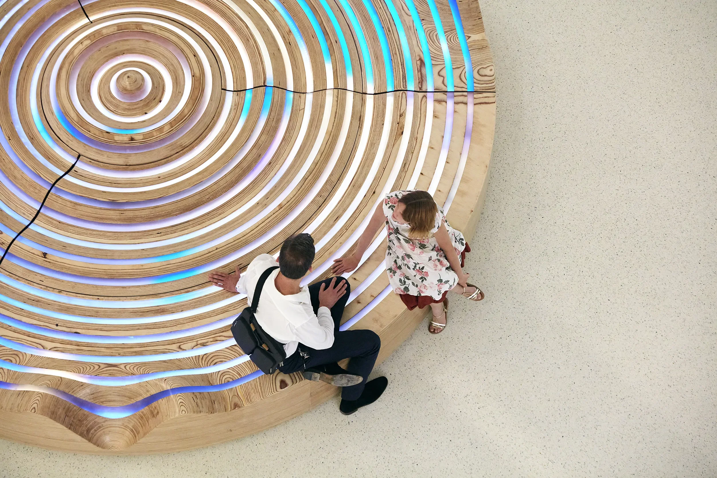 Overhead view of the Wishing Fountain custom wooden bench with integrated LED lighting with visitors seated