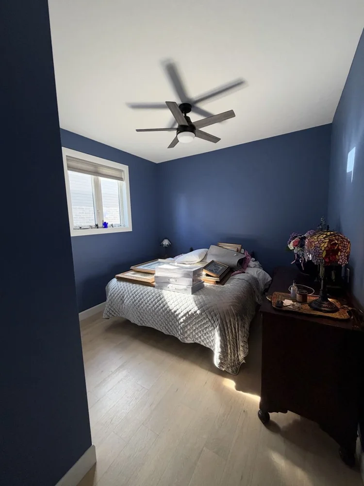 Guest bedroom painted deep navy with a white ceiling in Thamesford, Ontario