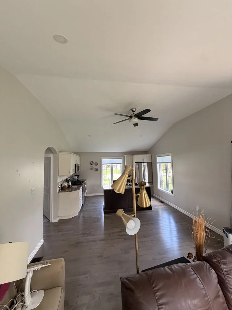 Open living area with a repaired and repainted vaulted ceiling