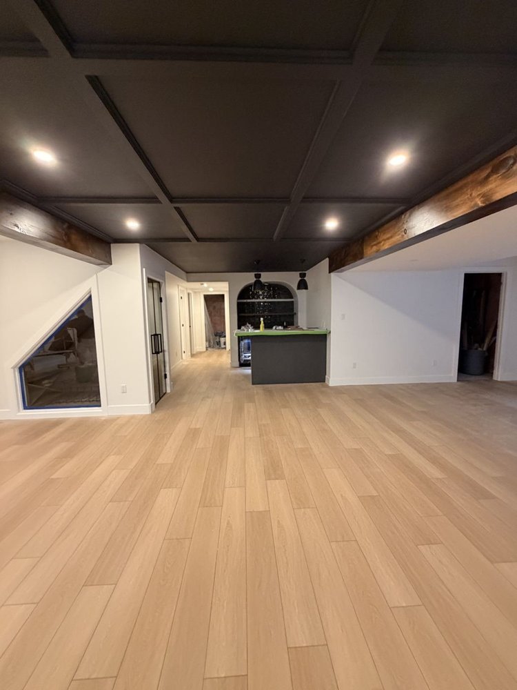 Finished basement with a black coffered ceiling and fresh white walls in Dorchester, Ontario