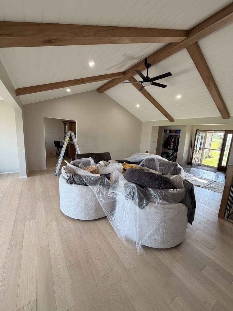 Vaulted great room with a white ceiling and wood beams after interior painting in Mossley, Ontario