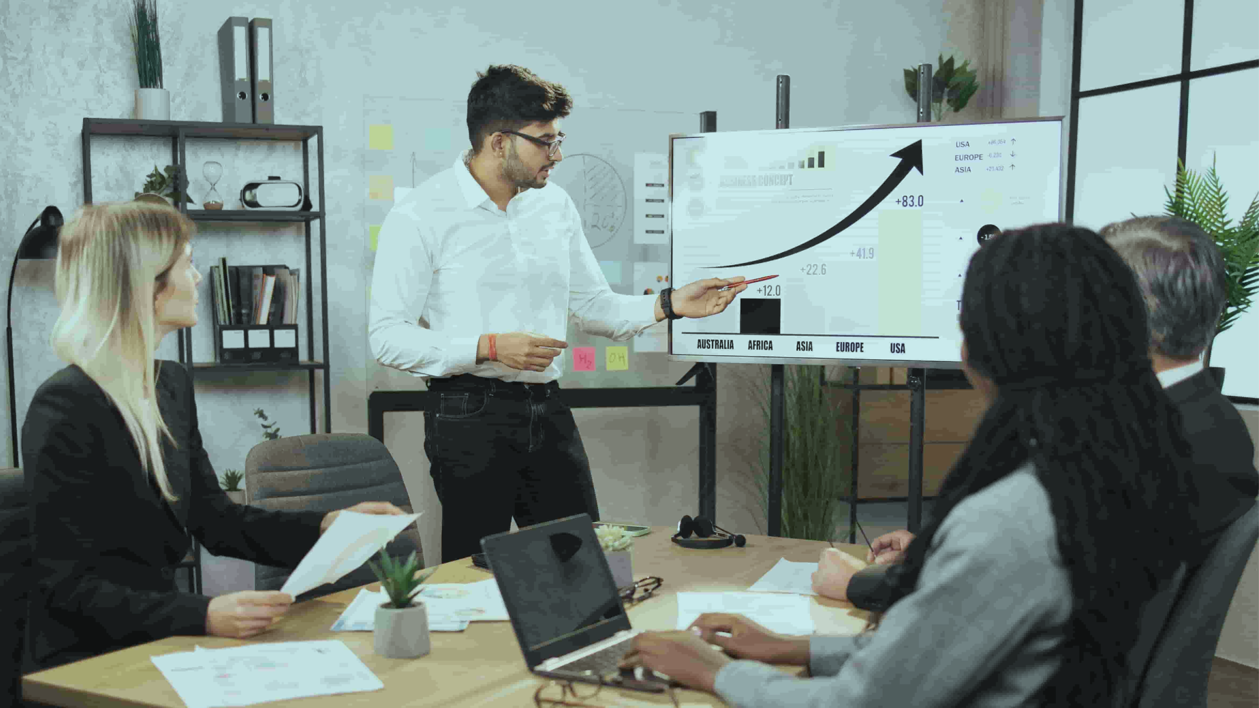 birdseye view of a handshake over a laptop and professional looking documents