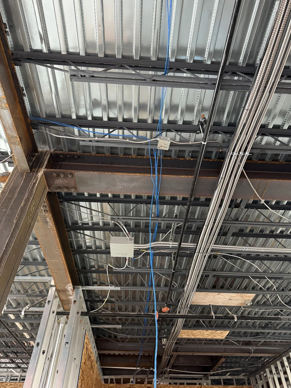 Cable run through steel ceiling framing on a commercial build