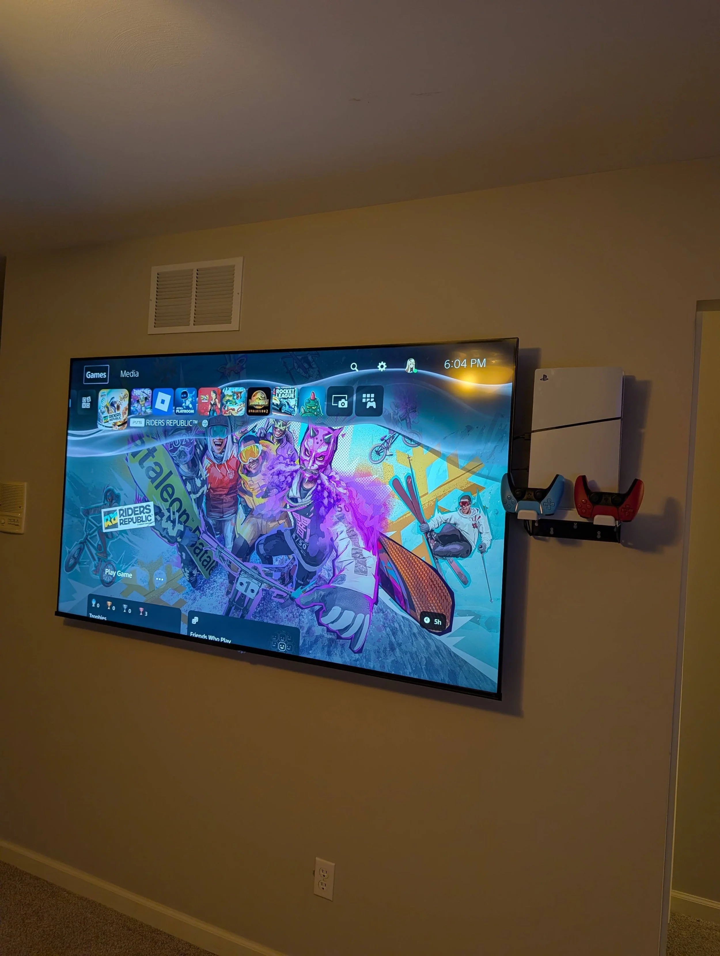 Flat-screen TV mounted on a living room wall with game console mounted beside it