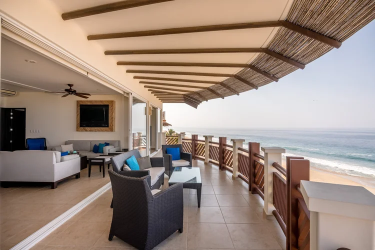 Wide shaded terrace with lounge and dining furniture facing the ocean at Unit 843, Building H, Vivo Resorts