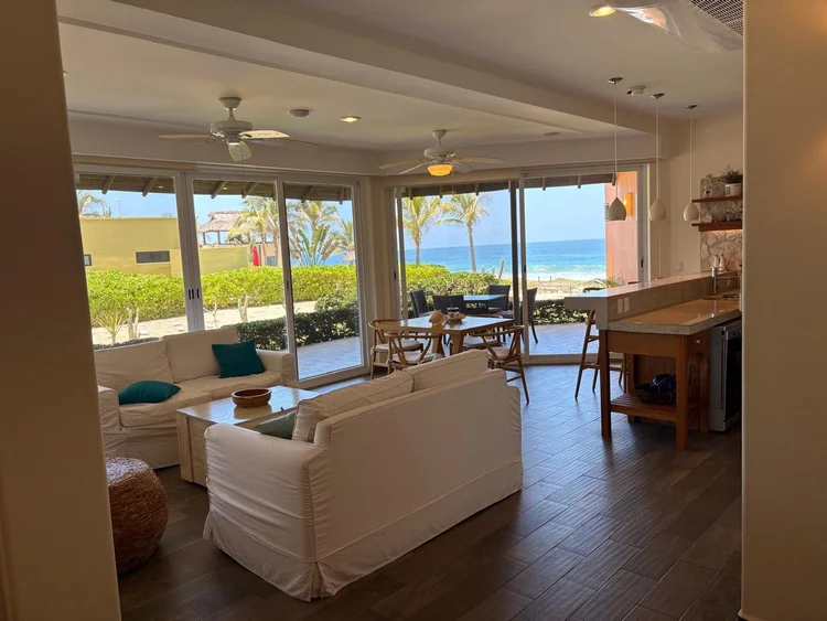 Living room with open sliding doors leading toward the beach at ground-floor Unit 612, Building F, Vivo Resorts