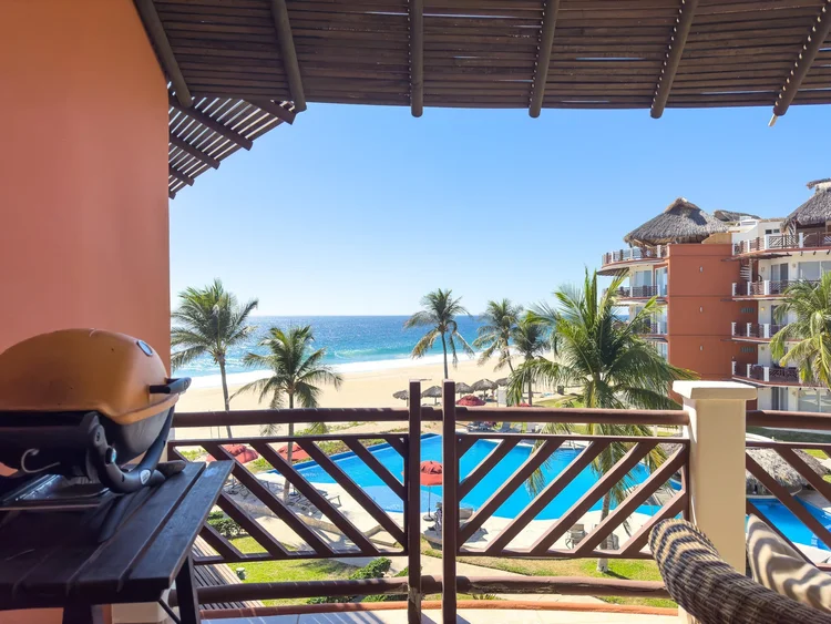 Balcony with grill overlooking the resort pools and the ocean from Unit 531, Building E, Vivo Resorts