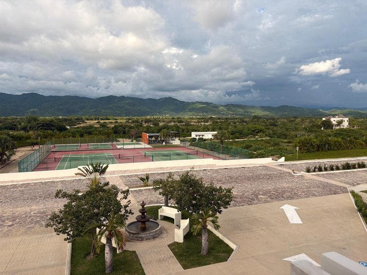 View from Unit 325 over the Clubhouse courtyard fountain and tennis courts to green hills, Vivo Resorts