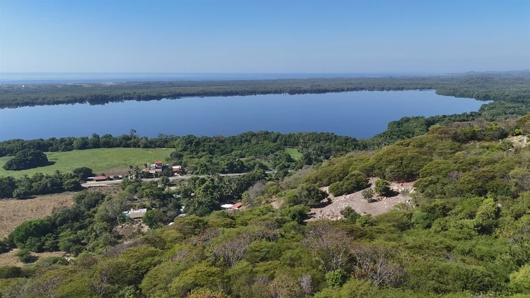 View over forested hills to the lagoon and the Pacific from Las Negras Lot H14 near Puerto Escondido