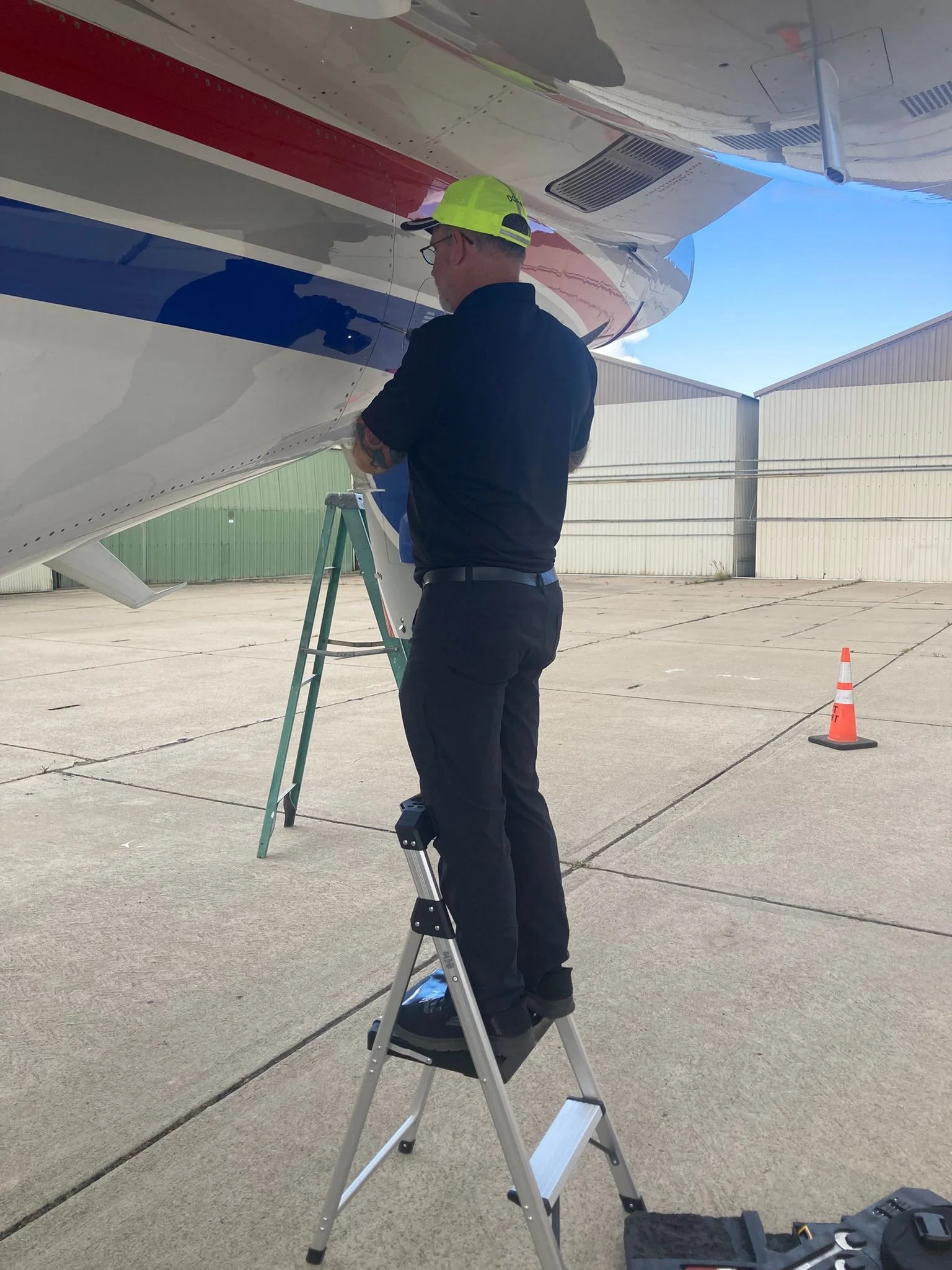 Don Jones on ladder inspecting fuselage