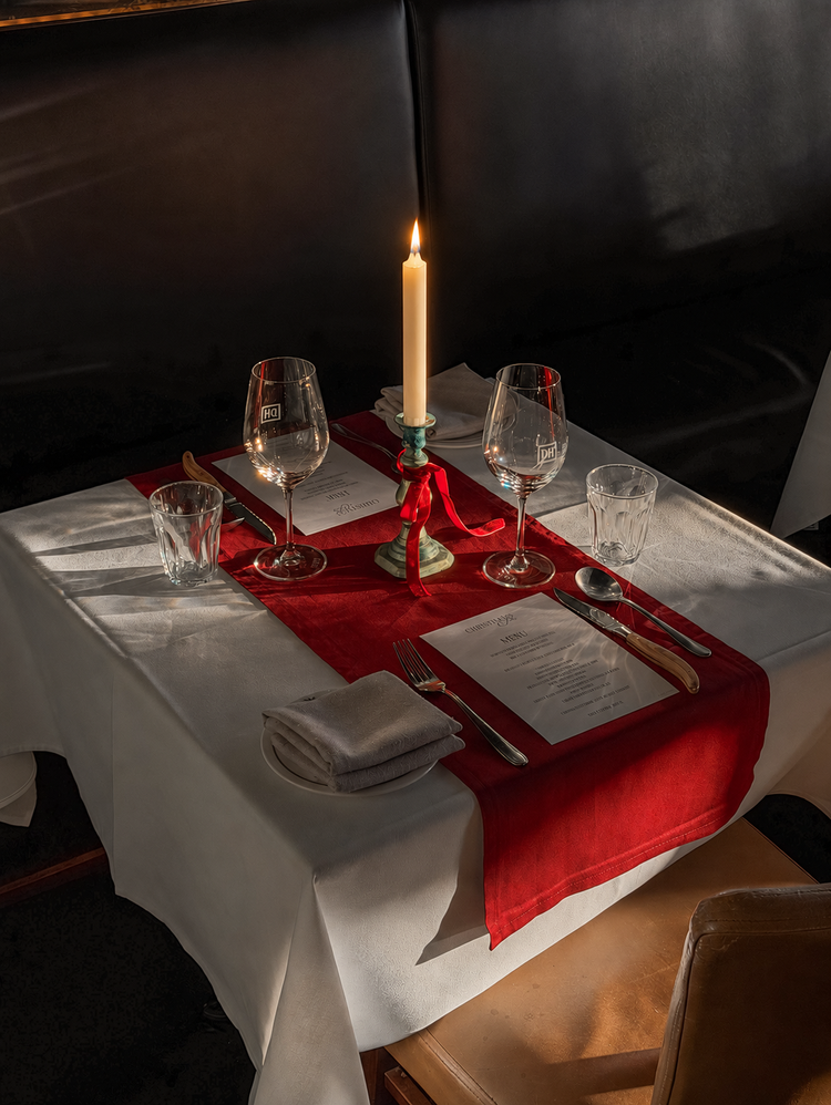 A lit ivory candle on the Christmas table