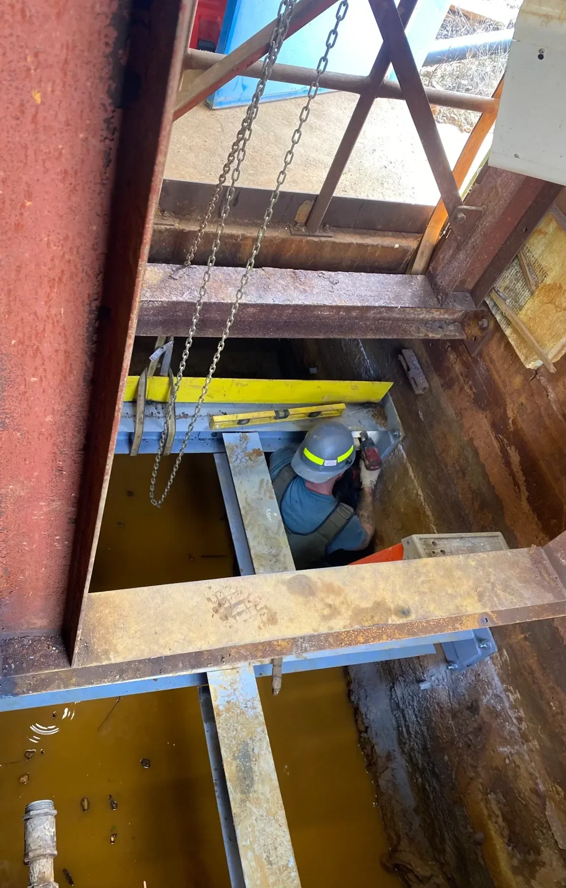 Dallaire technician working inside industrial equipment at the Pump House project