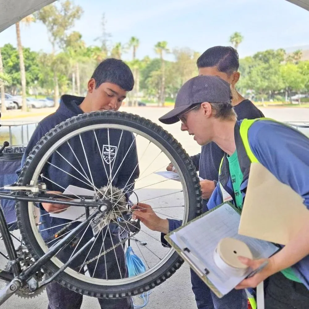 Students in Tijuana learn to adjust a bicycle wheel