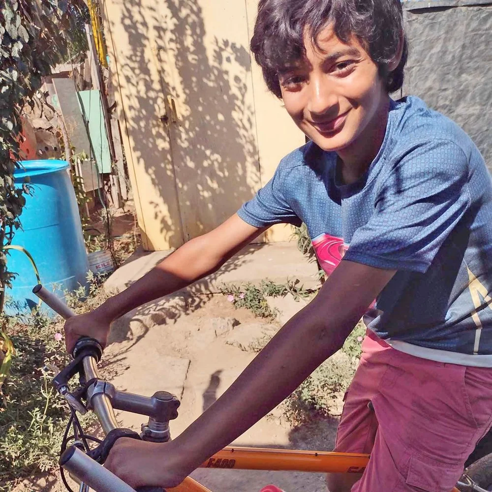 A smiling boy rides his new bike