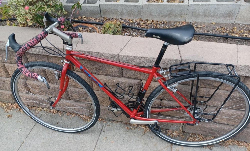 A red Bruce Gordon touring bike with a rear rack