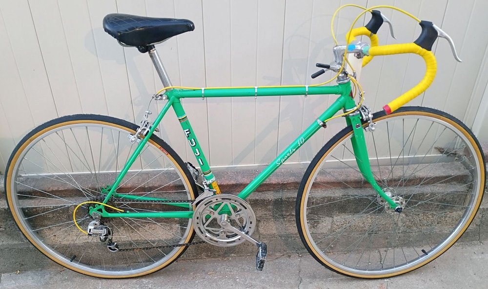 A green vintage Fuji road bike with yellow bar tape