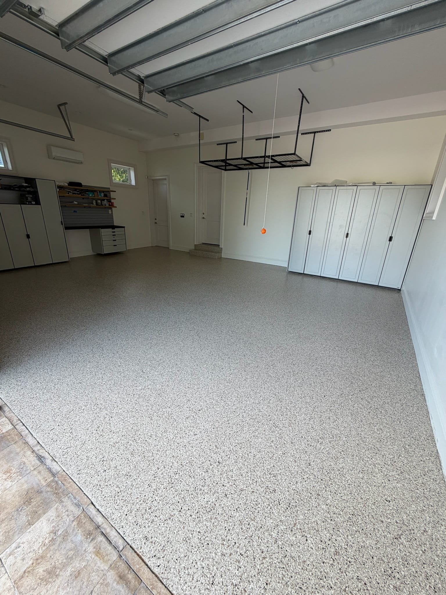 Gray flake garage floor with white storage cabinets