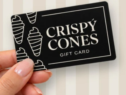 A hand holding a Crispy Cones gift card