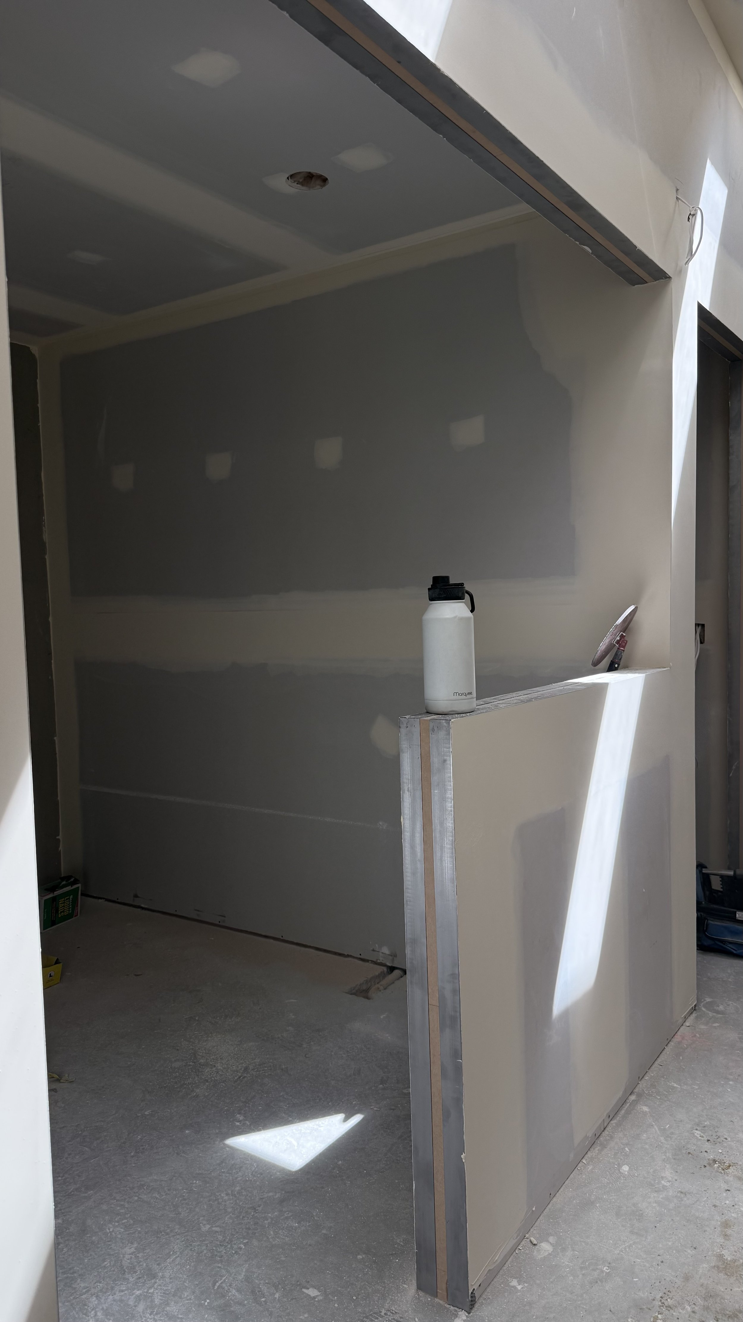 Crew member flushing plasterboard through window opening at vet clinic