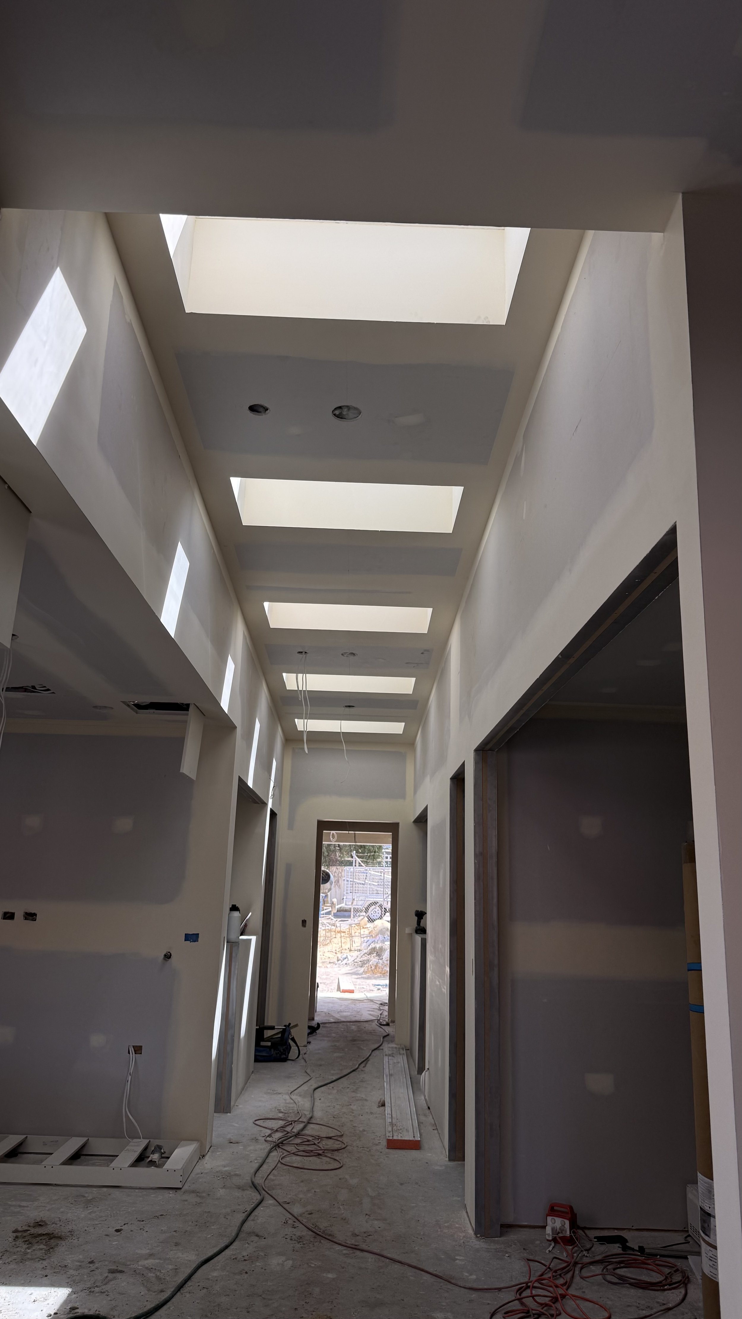 Flushed plasterboard corridor with doorways and ceiling detail
