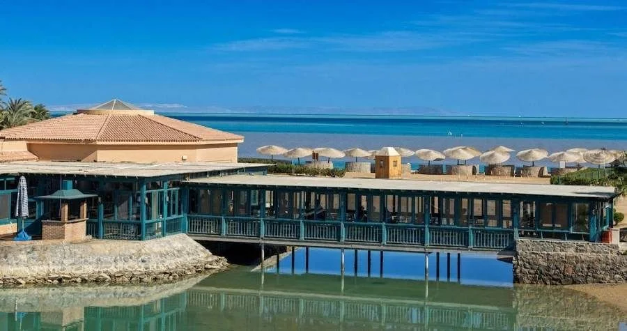 Passerelle couverte sur pilotis au-dessus de la lagune verte de l’ancien Club Med El Gouna (Égypte)