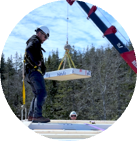Crew guiding a CLT panel into place by crane
