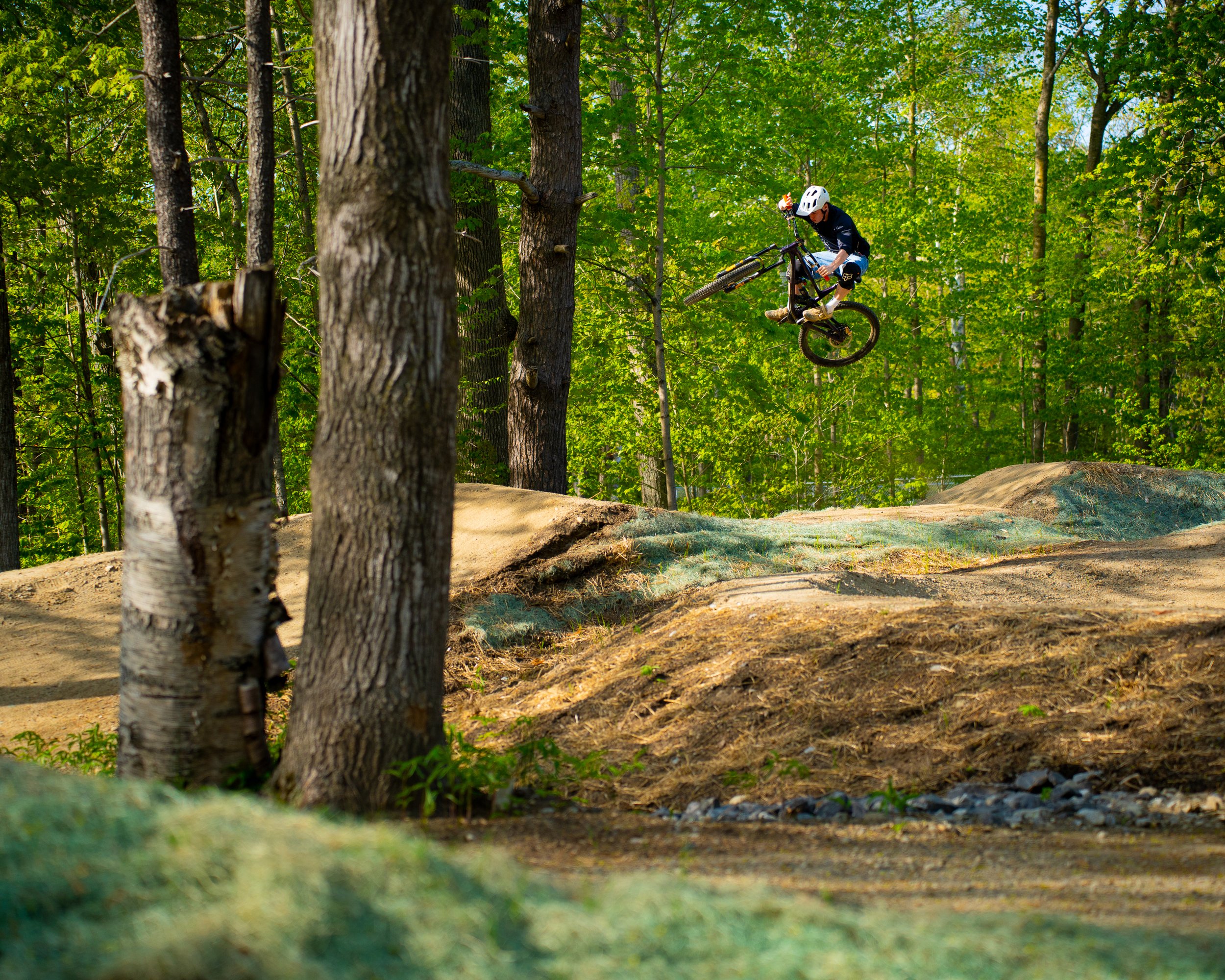 mountain biker hitting a big jump on a gravity trail