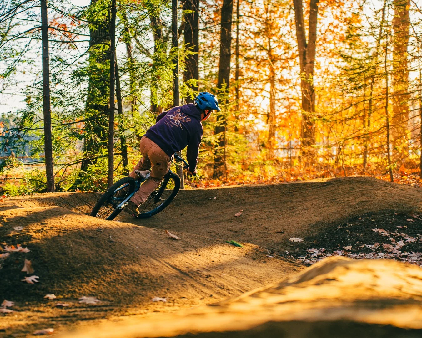 biker riding pump track at golden hour