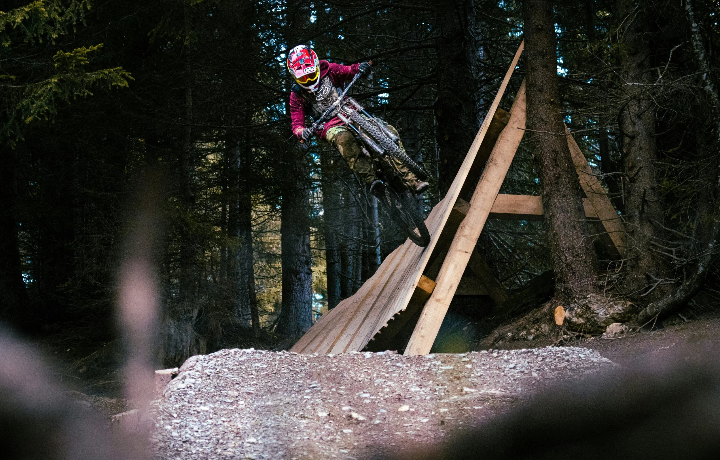 mountain biker riding a wooden feature at a bike park