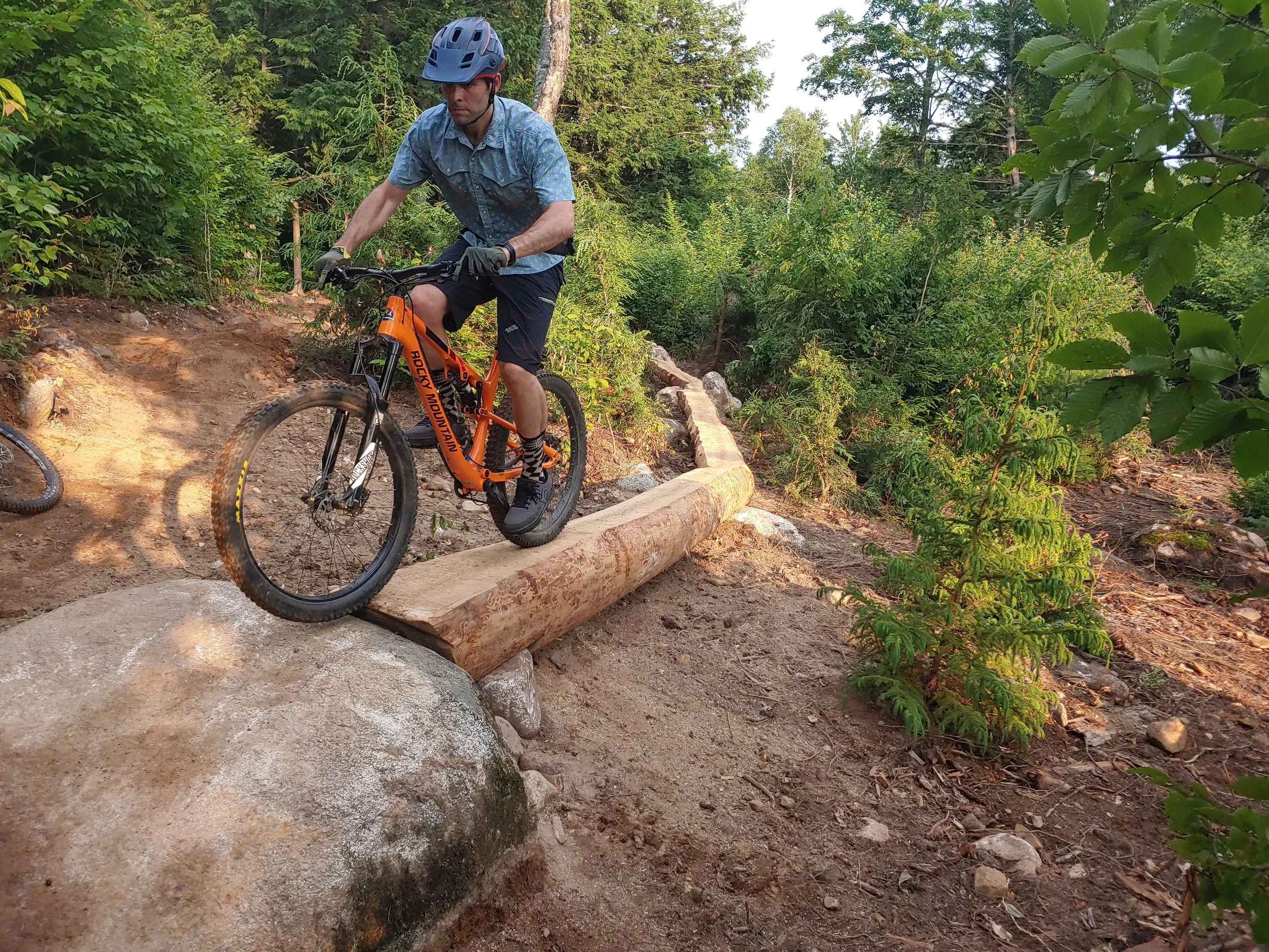 mountain biker riding a skinny made from old logs