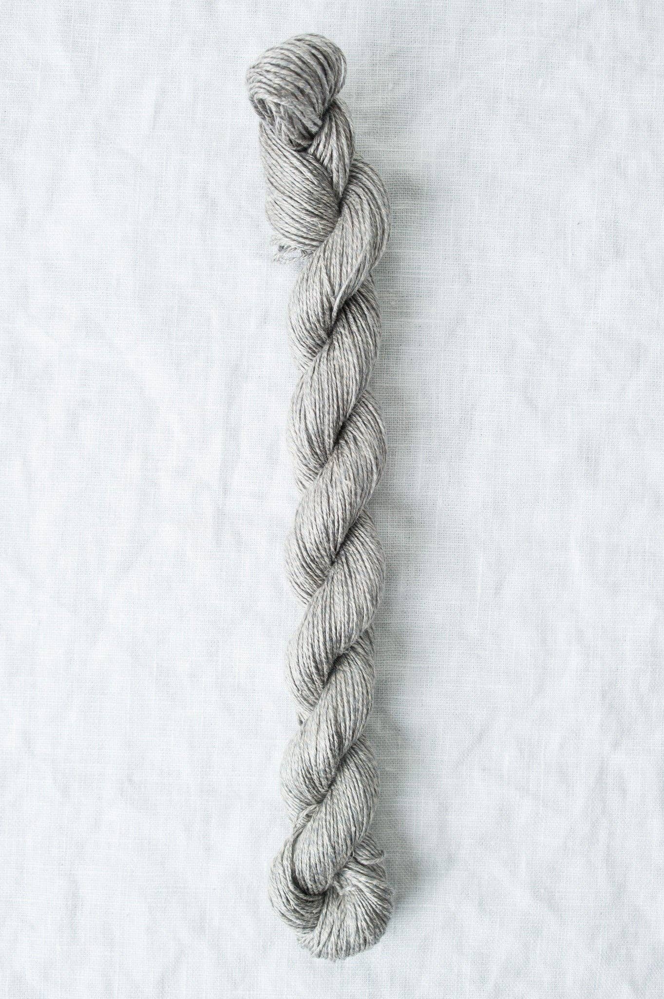 Grey organic linen yarn skein with crisp texture that softens after washing and wear.