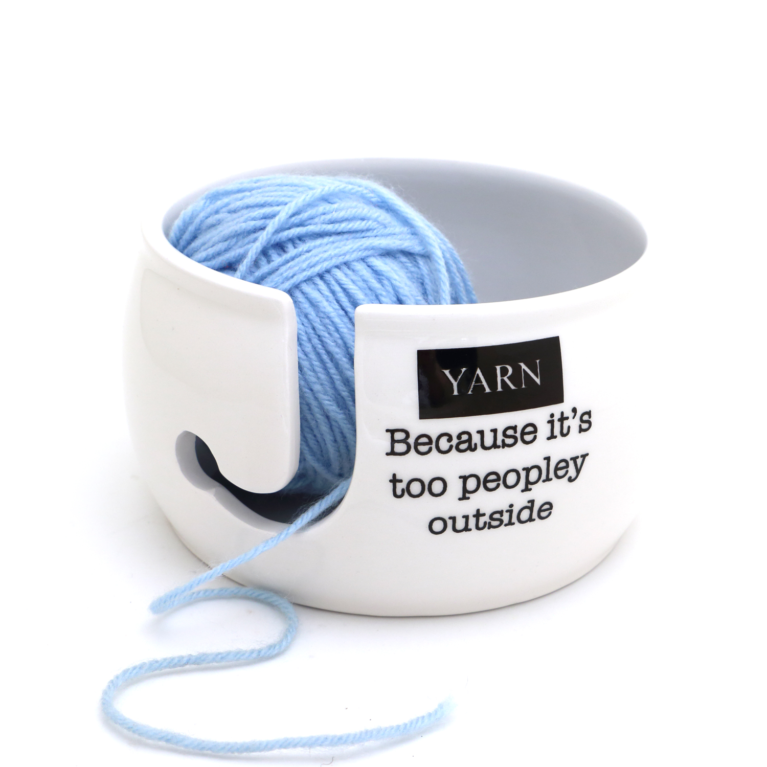 White ceramic quote yarn bowl holding a ball of yarn