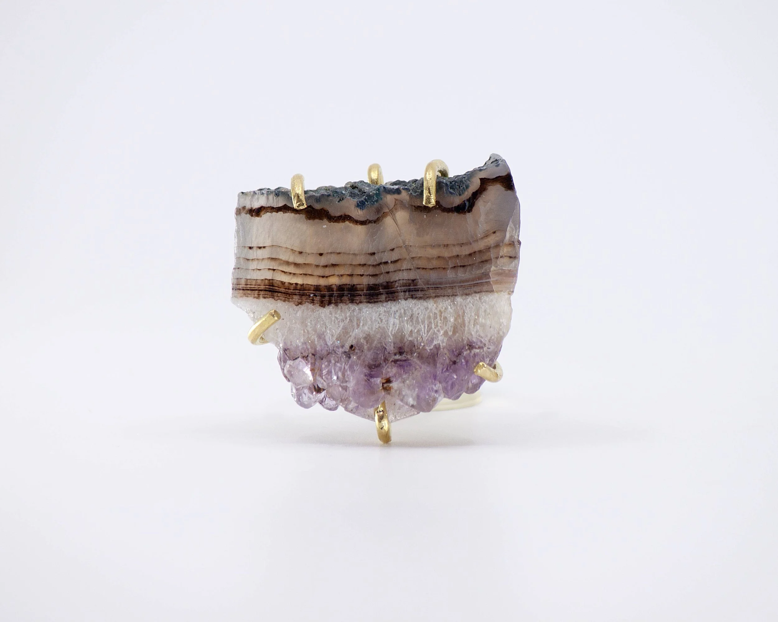 Raw amethyst slice ring set in gold-tone prongs, shown from the front.