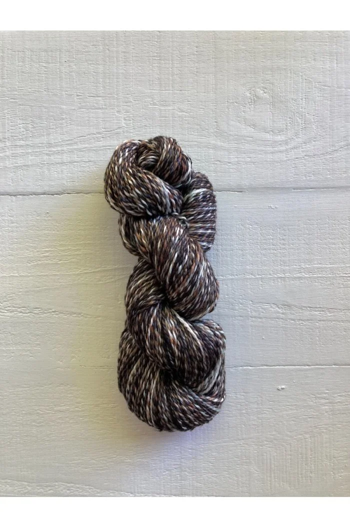 Brown and white speckled yarn skein with visible twist from Manos del Uruguay