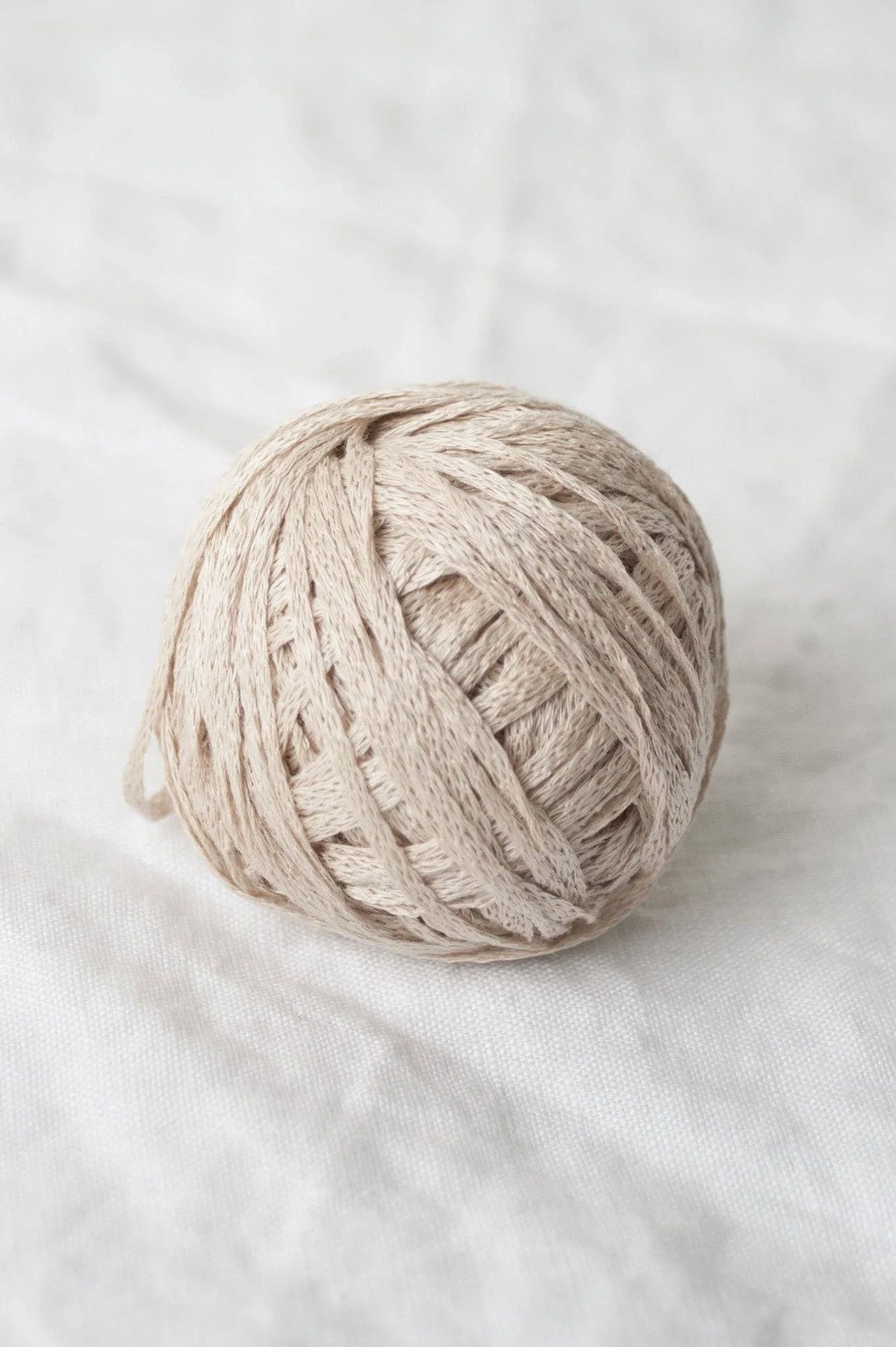 Beige organic yarn ball with soft twist, ideal for timeless neutrals and everyday projects.