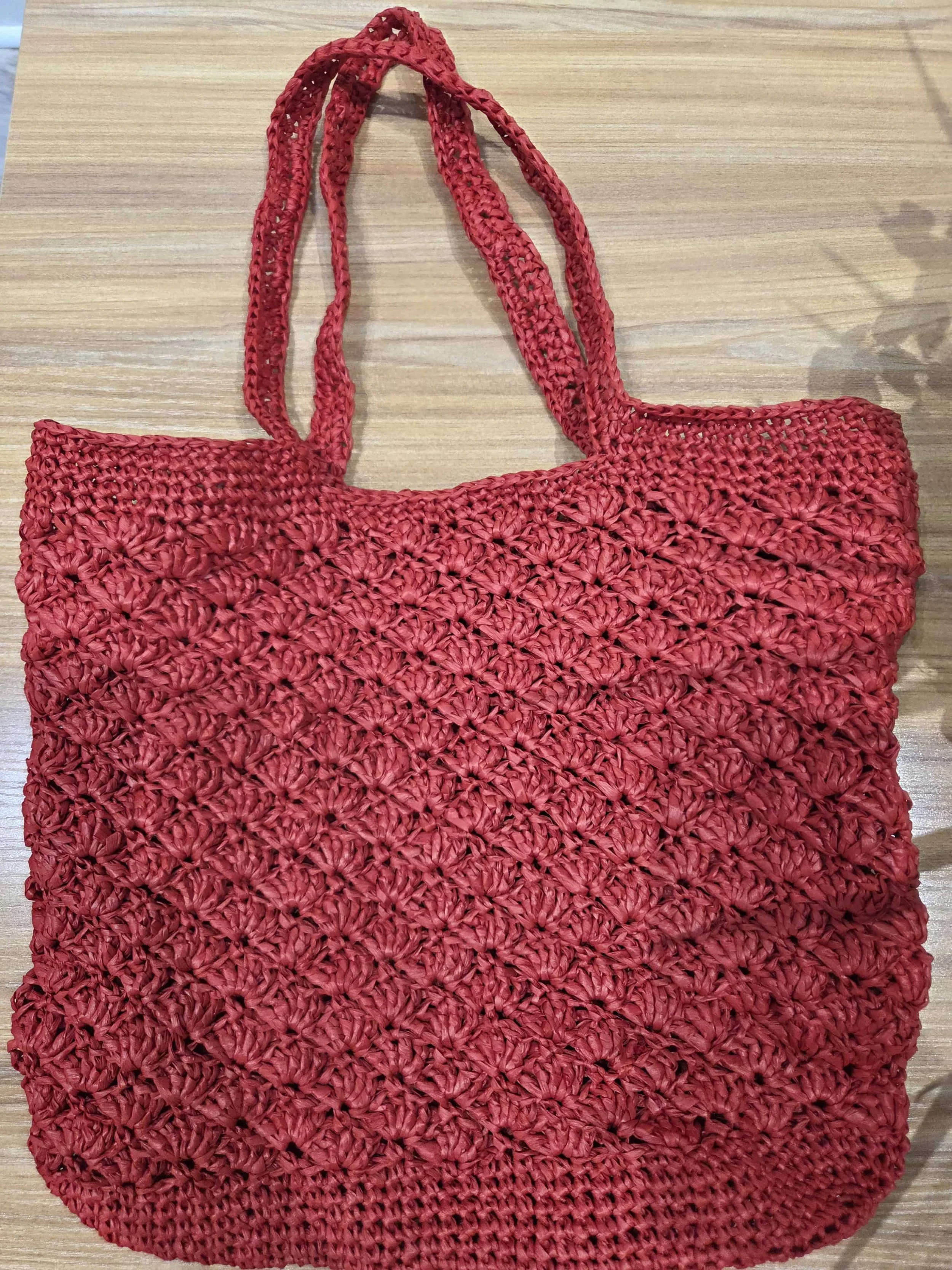 Close-up of handmade red crochet tote bag using cotton yarn and shell stitch, a finished project from AriYARN Shop and Studio.