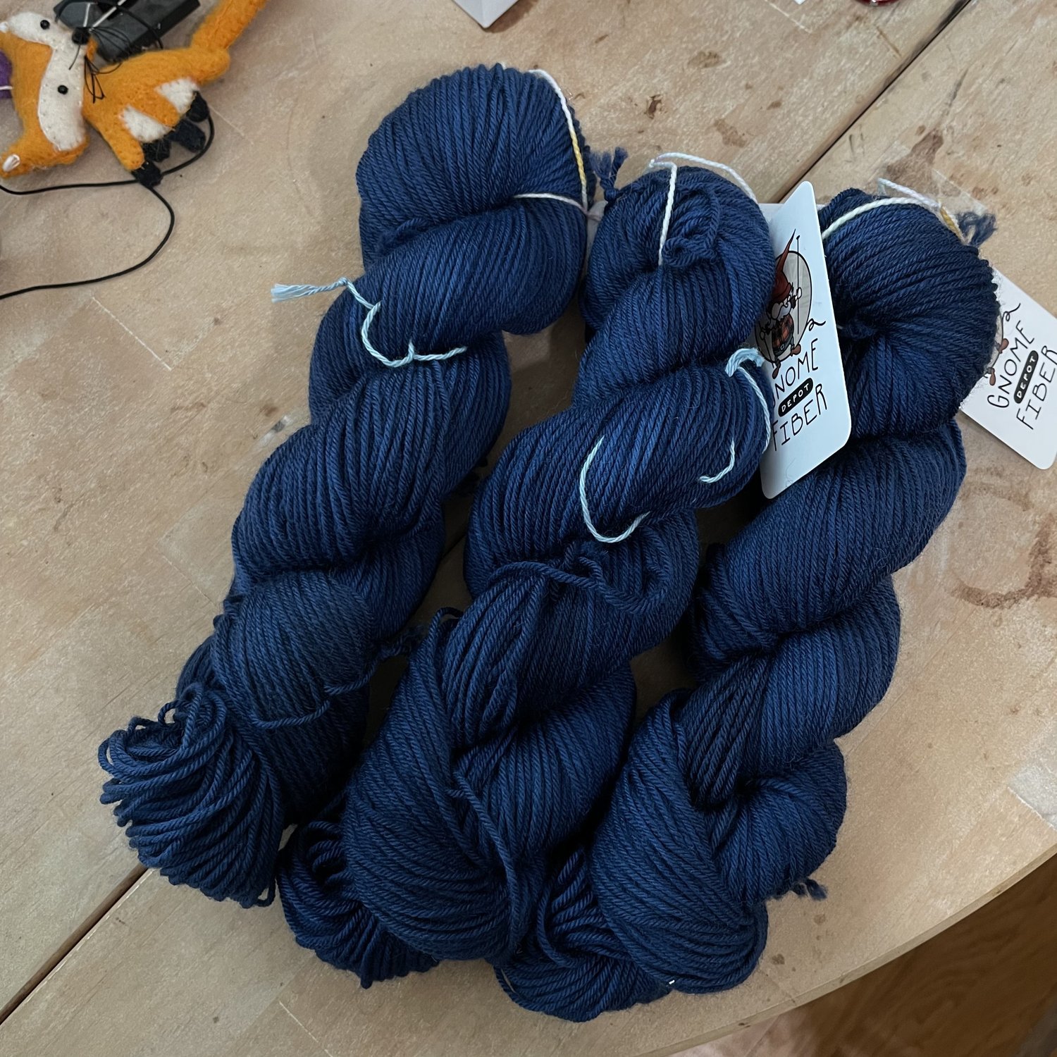 Gnome Depot DK-weight yarn skeins in deep navy and dark blue tones.