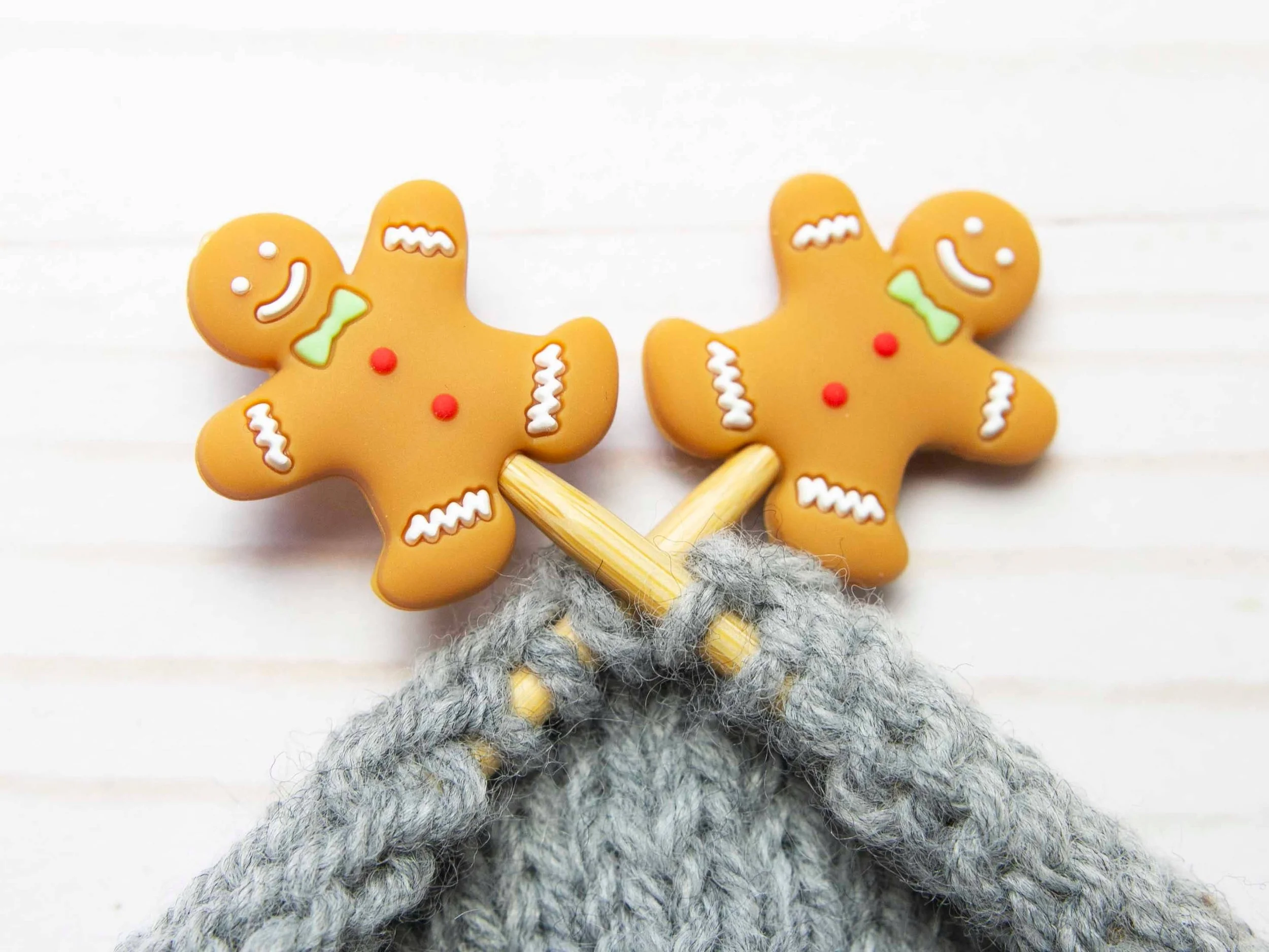 Gingerbread point protectors on wooden needles with gray knit fabric