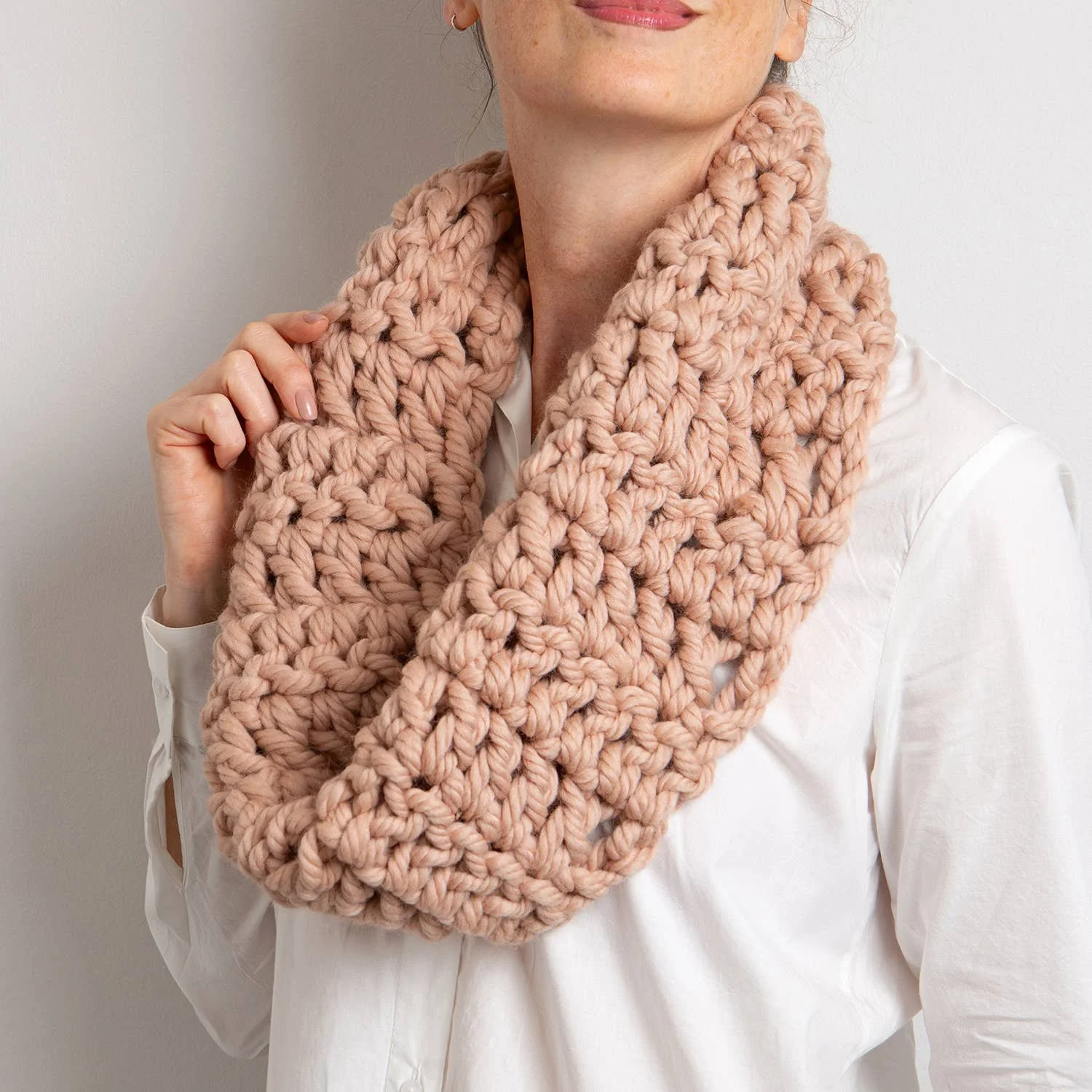 Student wearing a blush super-chunky crochet cowl completed in class.