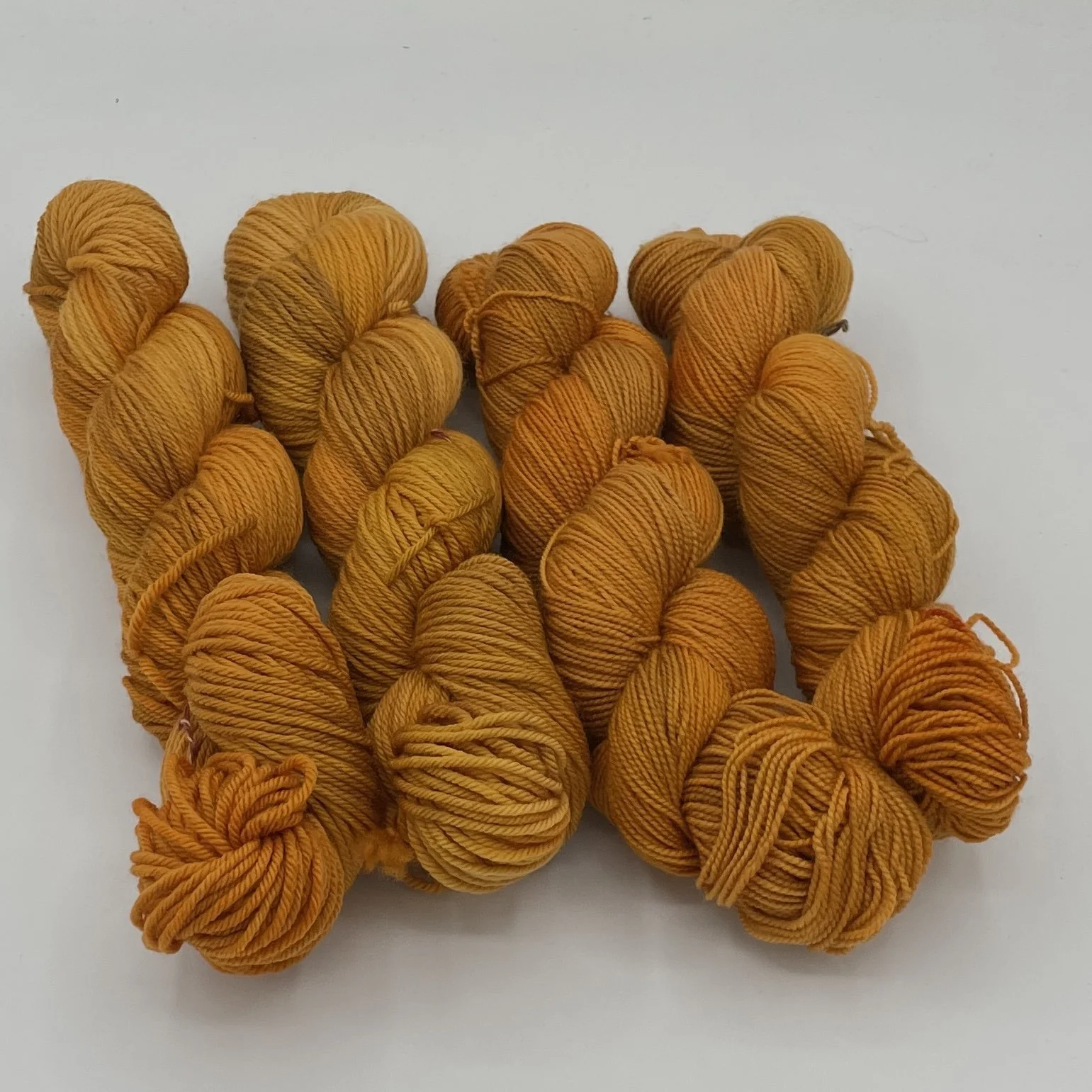Portobello Bulky yarn hanks in a solid orange-brown shade.