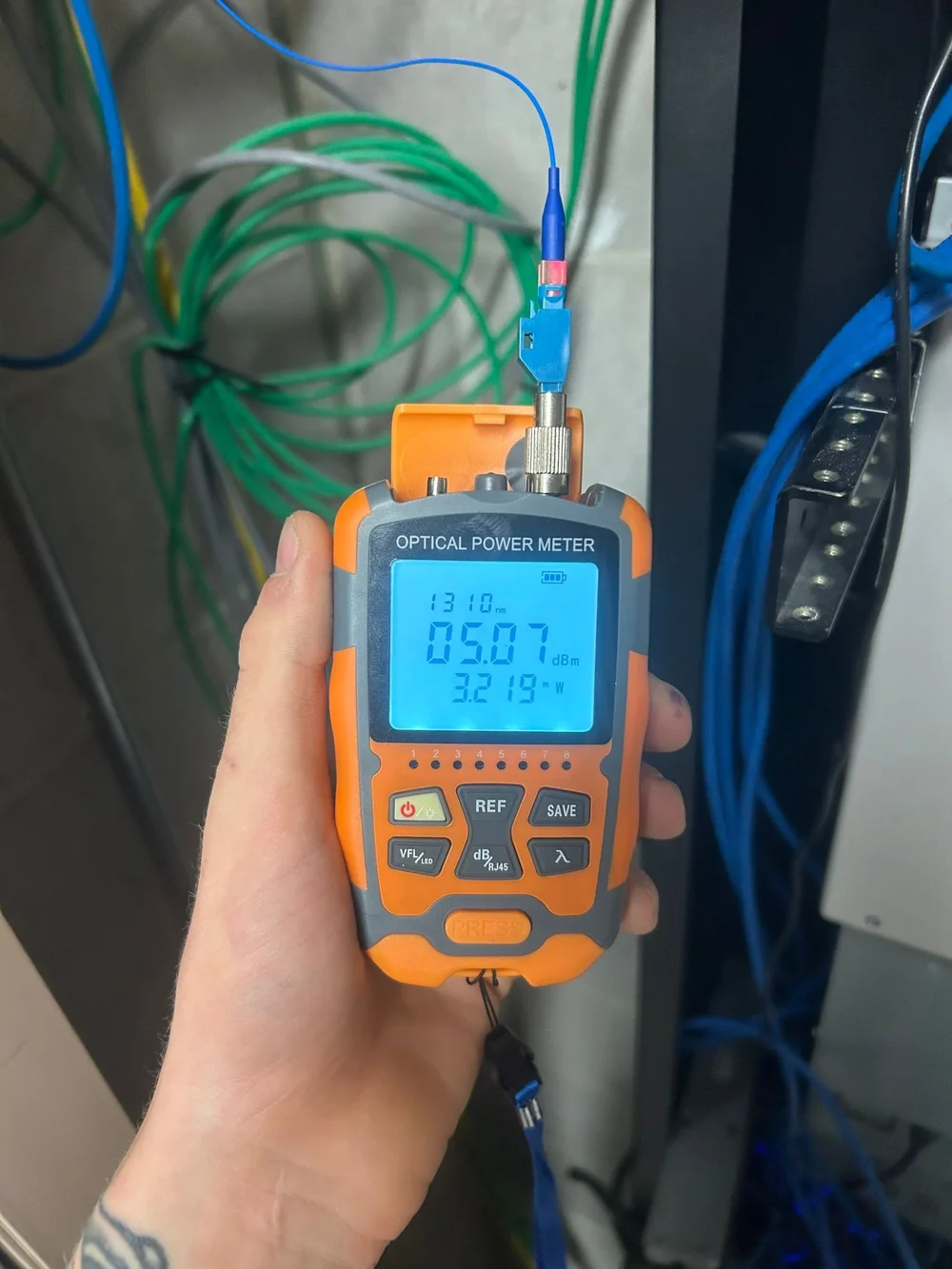 Close-up of an optical power meter connected to fiber during testing
