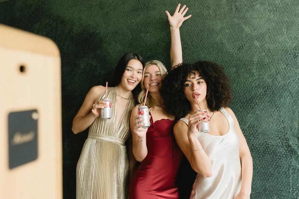 Guests at the digital photo booth set up against a plain wall, no backdrop
