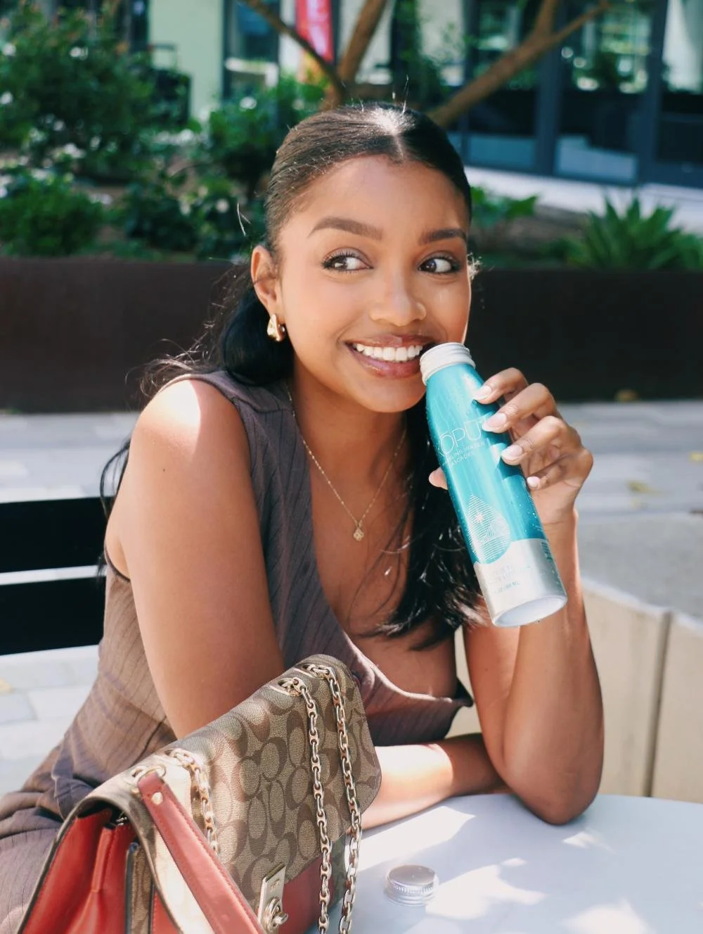 Creator holding a KOPU sparkling water bottle on a Los Angeles patio