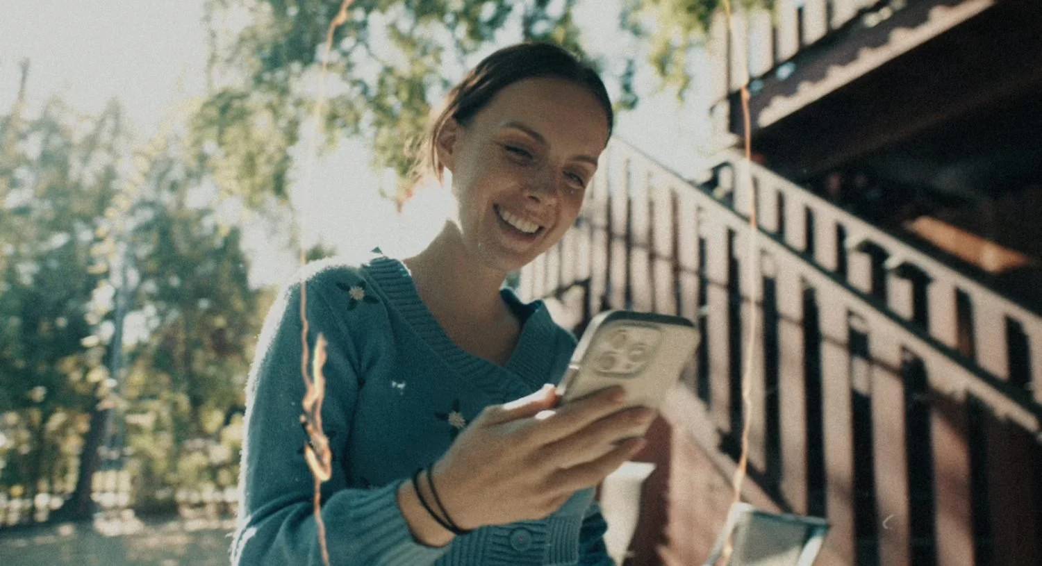 Creator content still, talent filming on a phone outdoors