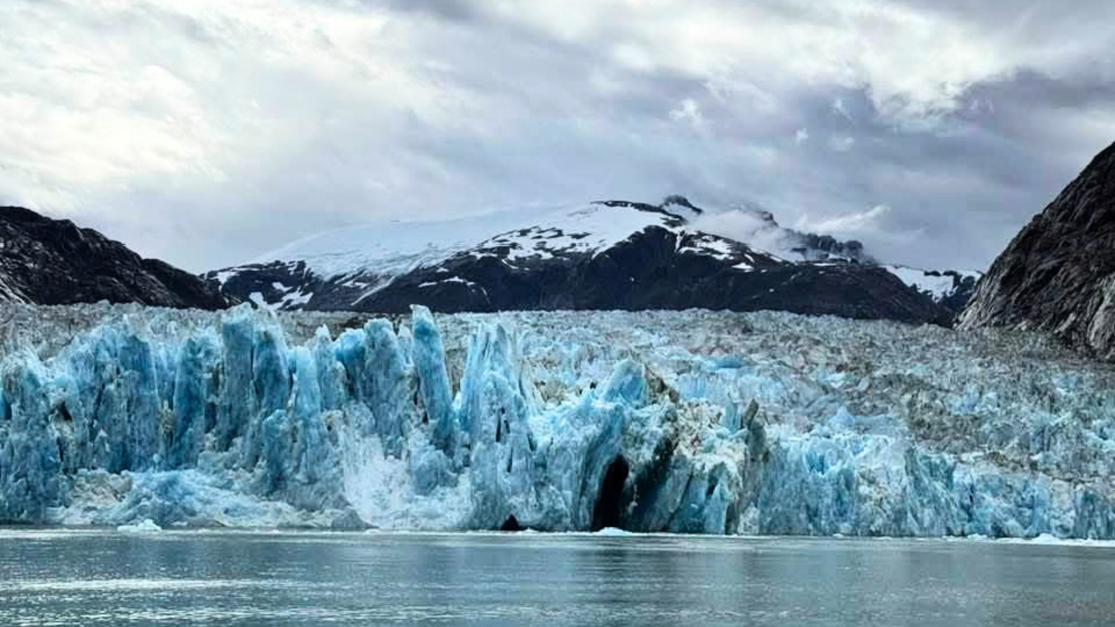 A blue glacier face meeting the water in Alaska.