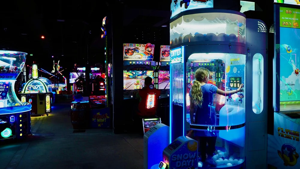 Un élève devant une rangée de jeux d'arcade